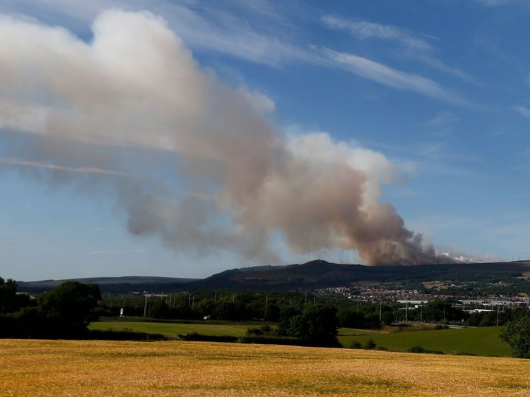 Smoke rises from a grass fire on Winter Hill near Bolton