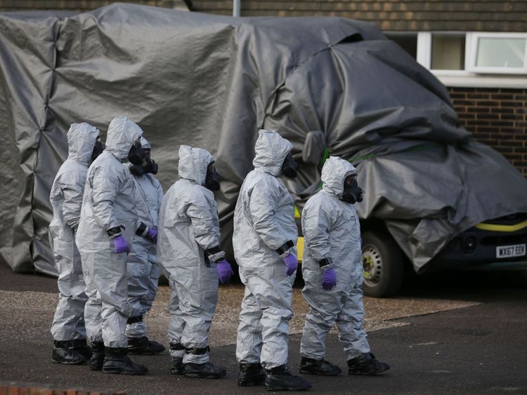 Personnel in protective coveralls and breathing equiptment cover an ambulance with a tarpaulin at the Salisbury District Hospital in Salisbury, southern England, on March 10, 2018