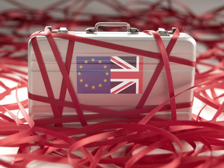 Red tape around a briefcase with european and british flags 